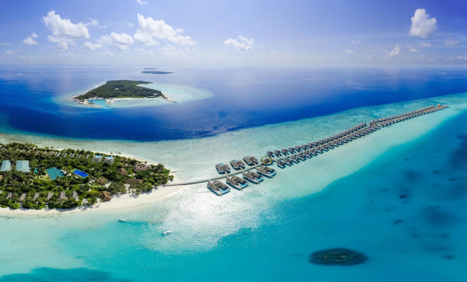 Resort din Maldive cu vile pe apă, mare turcoaz și insule tropicale, vacanță exotică de lux
