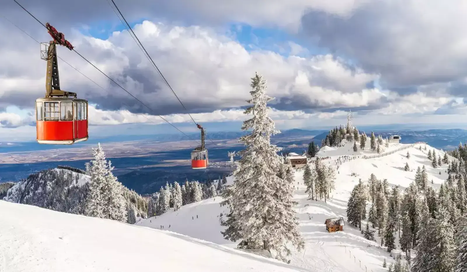 Telecabină &icirc;n Poiana Brașov, peisaj montan acoperit de zăpadă.